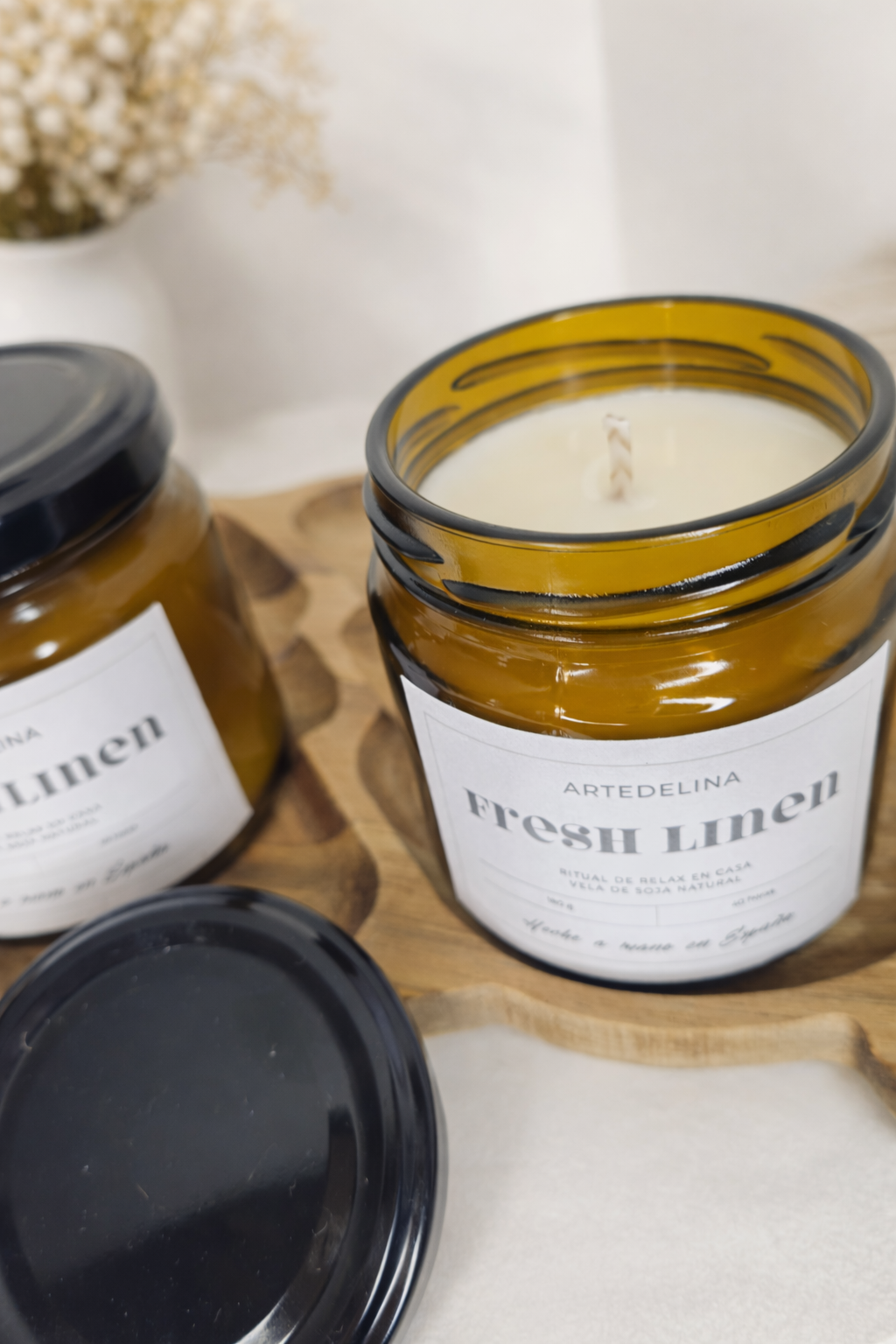 Vela Fresh Linen 180g encendida creando ambiente fresco y acogedor en el hogar